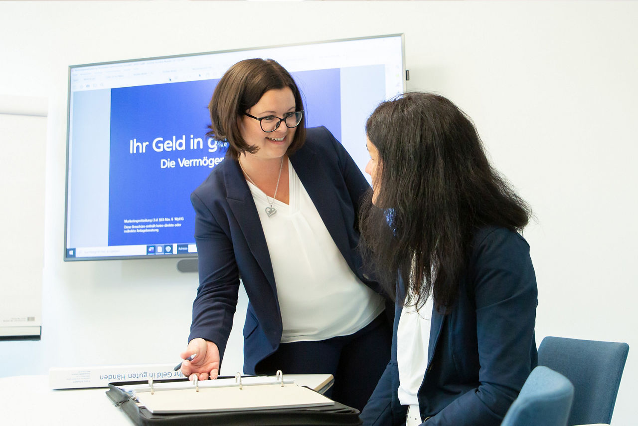 Zwei Frauen sprechen miteinander in einem Büro