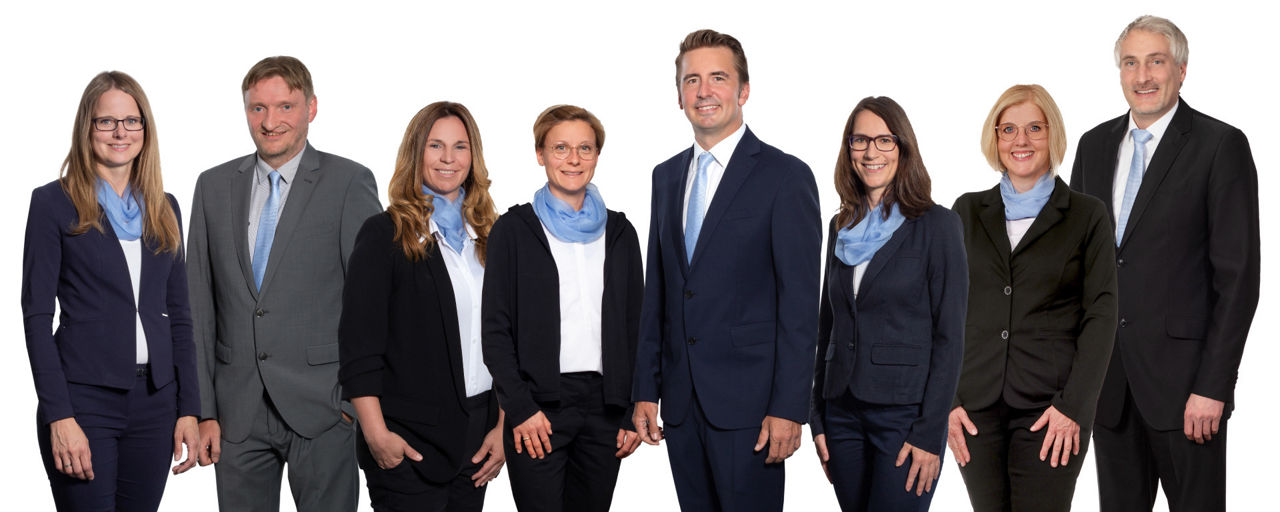Fünf Frauen und drei Männer nebeneinander aufgestellt. Alle lächeln freundlich.
