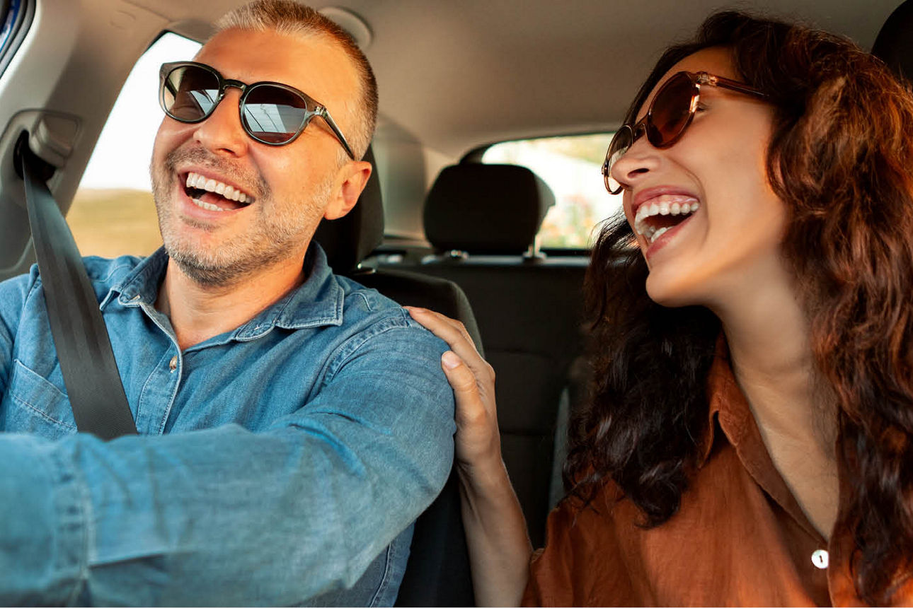 Lachendes Paar sitzt im Auto