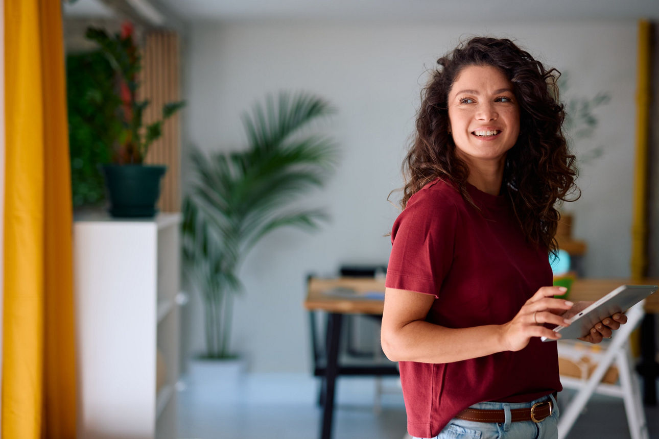 lächelnde junge Frau hält Tablet in der Hand