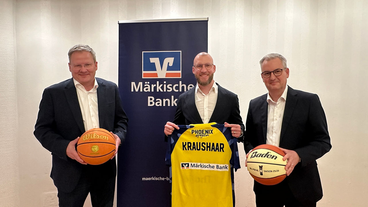 Achim Hahn, Martin Schmidt und Artur Merz vor einem Banner der Märkischen Bank und mit Basketbällen & Trikot in den Händen
