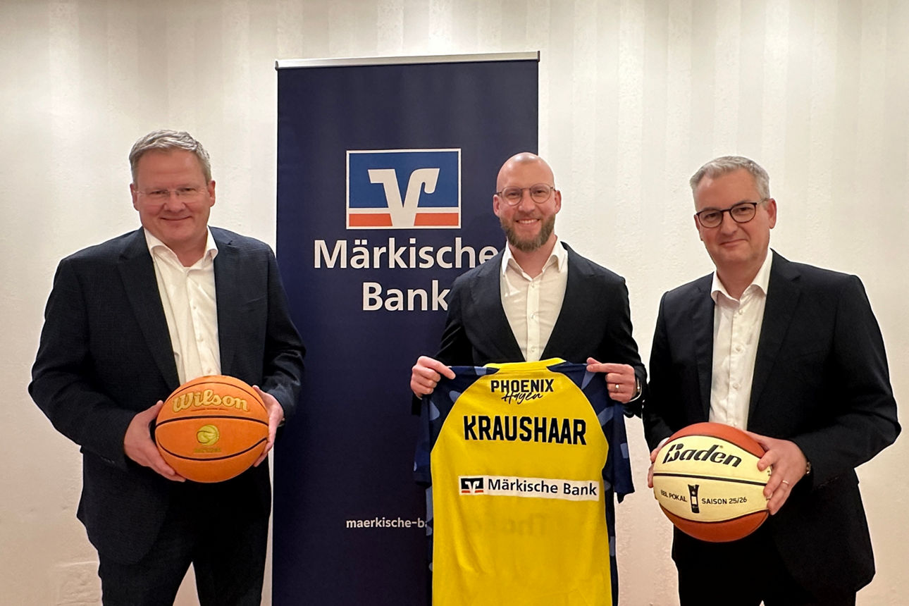 Achim Hahn, Martin Schmidt und Artur Merz vor einem Banner der Märkischen Bank und mit Basketbällen & Trikot in den Händen