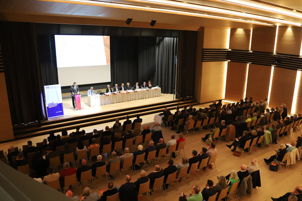 Saal mit Menschen vor einem Redner
