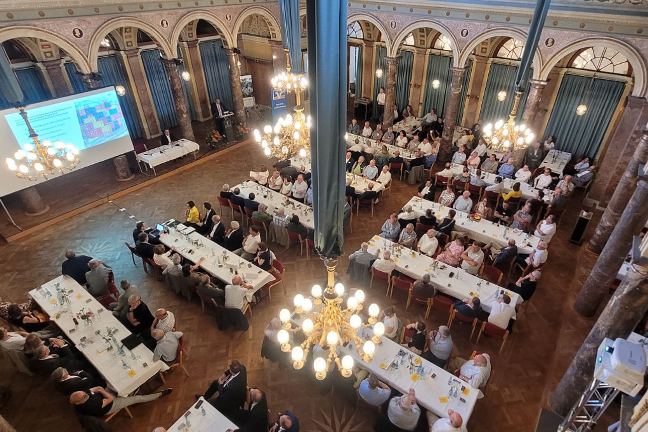 Vertreter der Bank sitzen während der Vertreterversammlung an Tischen im Marmorsaal Bad Ems.