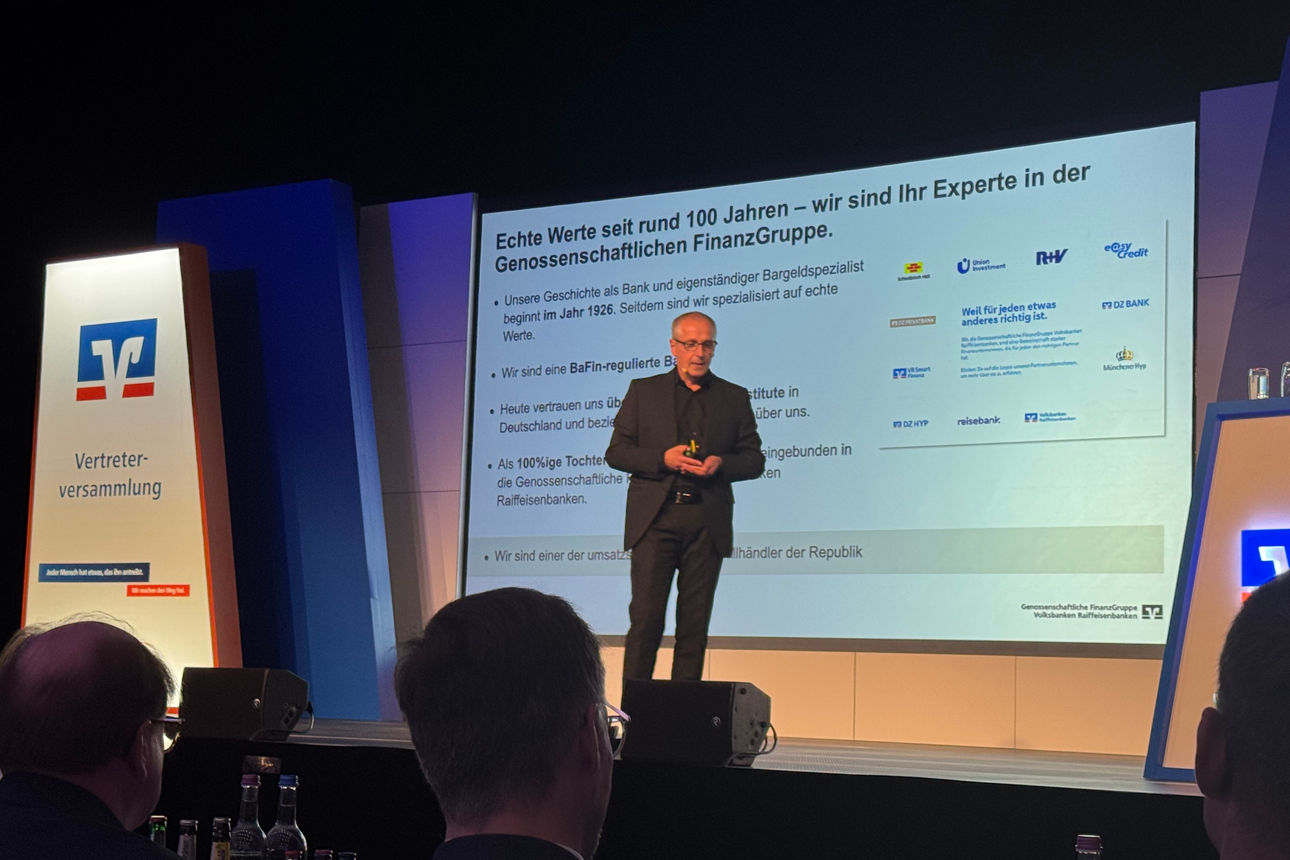 Reisebankvertreter auf der Bühne bei seinem Vortrag über Gold
