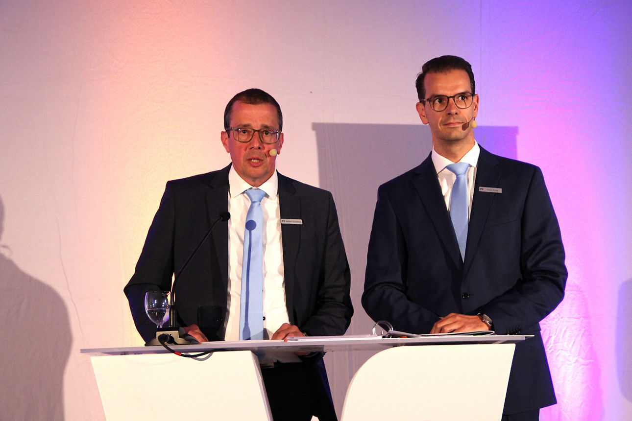 Auf der Vertreterversammlung der Volksbank Schermbeck stehen die Vorstände Norbert Scholtholt und Stefan Korte nebeneinander am Rednerpult. 