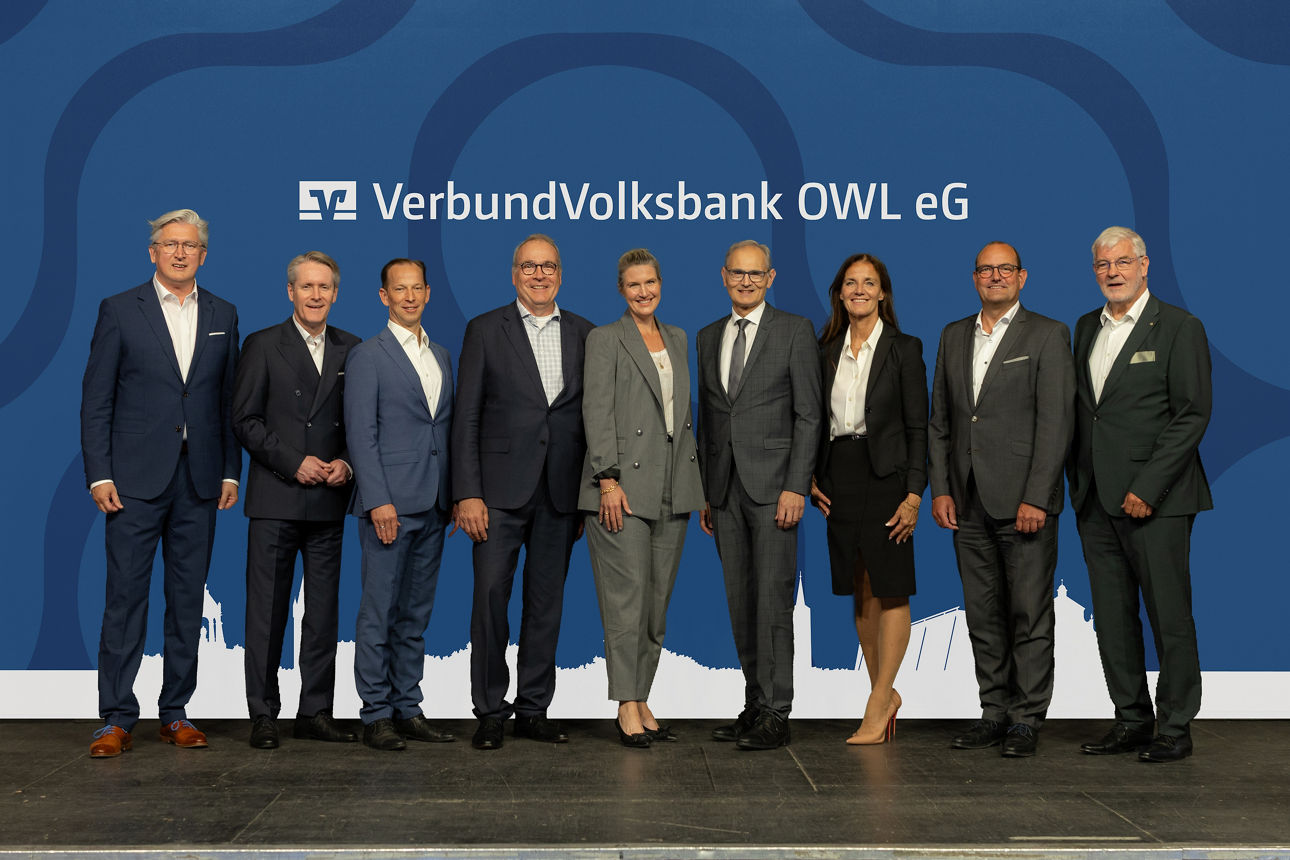 Vorstandsmitglieder und Aufsichtsratsmitglieder der VerbundVolksbank OWL eG stehen auf der Bühne.