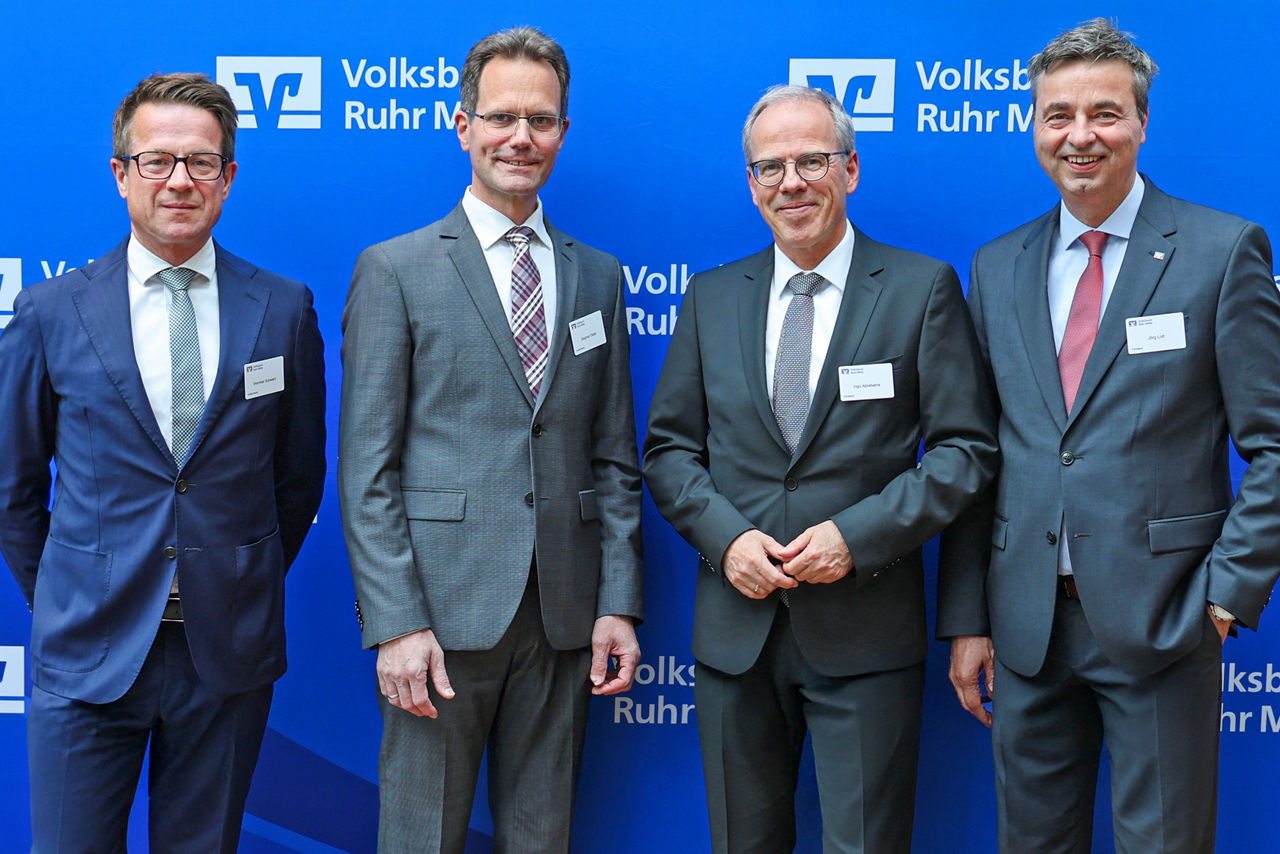 Vor einer blauen Pressewand mit Volksbank Ruhr Mitte Logos stehen vier männliche Personen in Anzug und Krawatte. Von links nach rechts: Wernher Schwarz und Stephan Dieler aus dem Aufsichtsrat und weiter Ingo Abrahams und Jörg Lott aus dem Vorstand der Volksbank Ruhr Mitte.