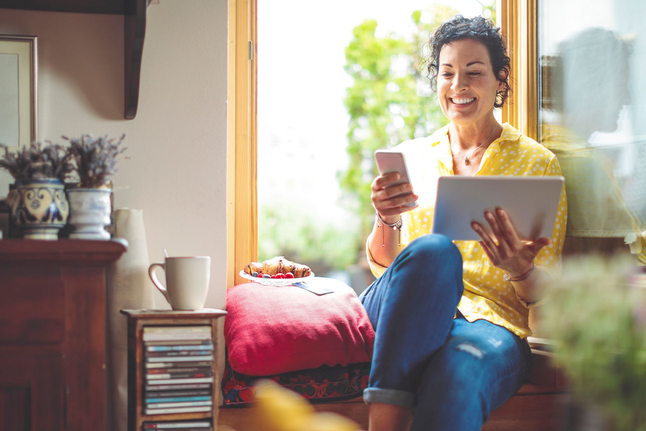 Frau mit Tablet und Smartphone in den Händen