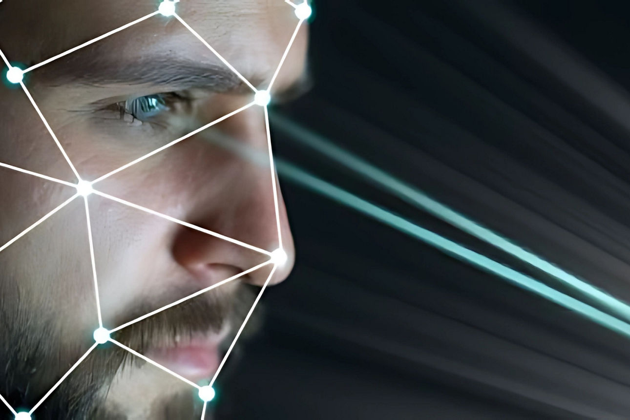 Ein männliches Gesicht mit einen Datennetz überzogen und Strahlen aus den Augen.