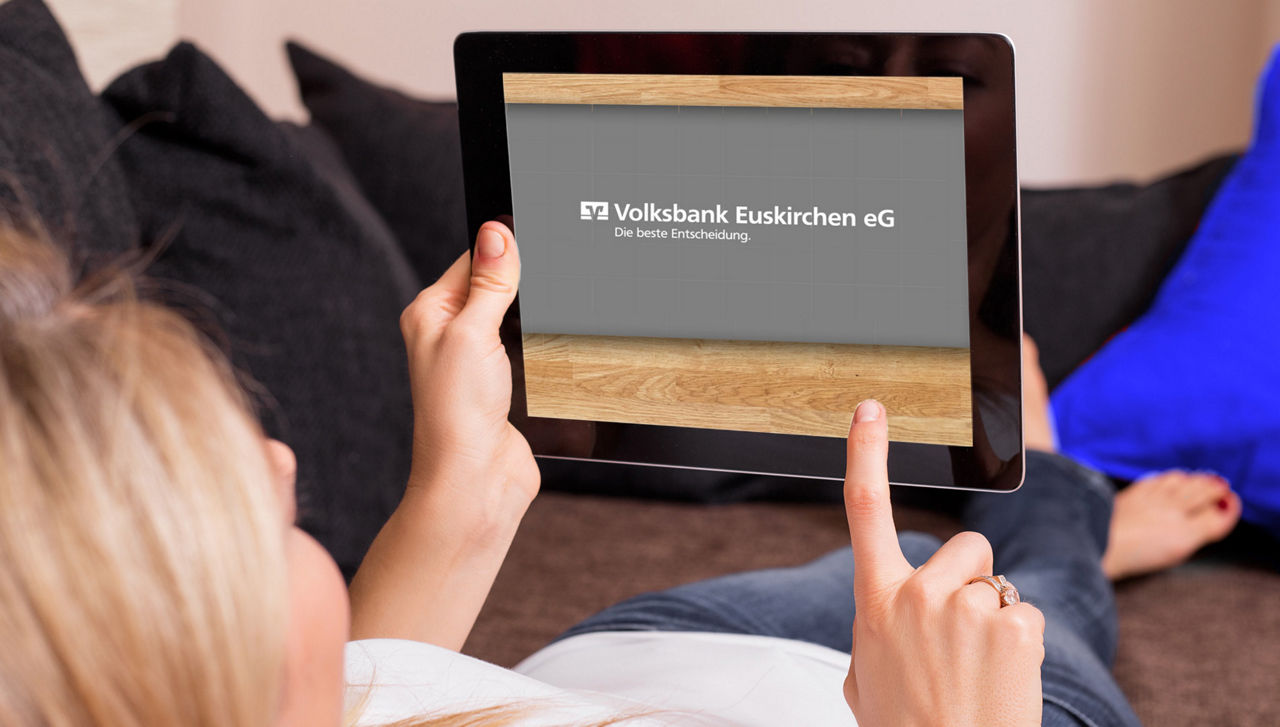 eine Frau liegt auf dem Sofa mit einem Tablet in der Hand