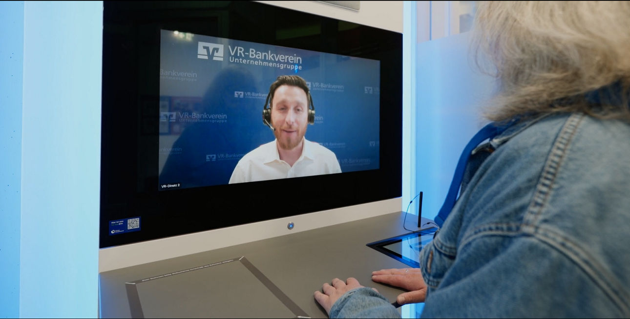Eine Kundin spricht mit einem Servicemitarbeiter per Videoschaltung