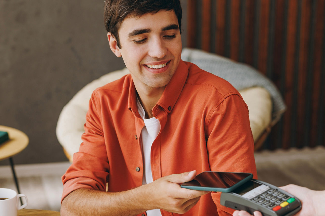 Junger Mann sammelt Cashback mit MeinPlus im Café