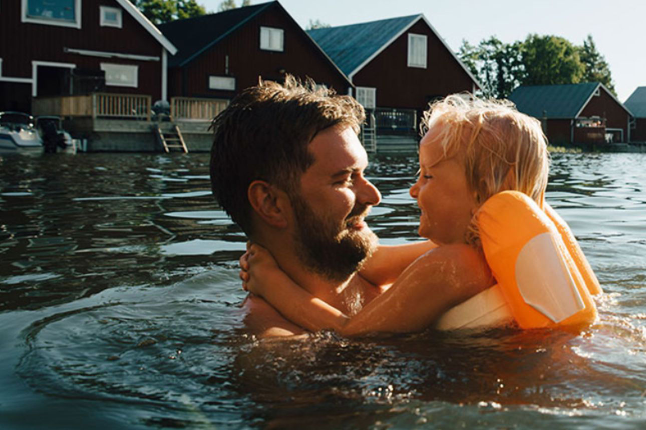 Vater badet mit Kind im See