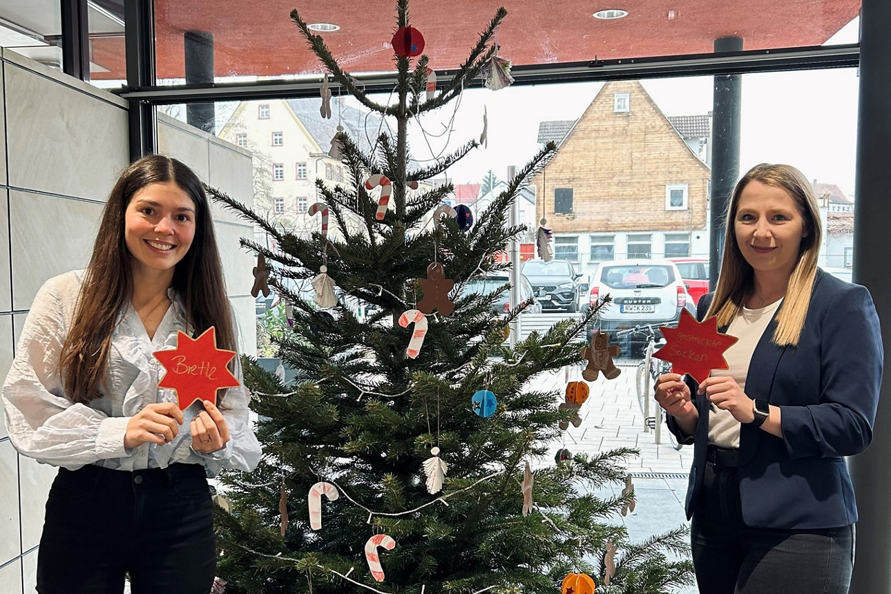 Mitarbeiterinnen Alina Ernst und Deborah Stofer mit Wunschstern vor Weihnachtsbaum