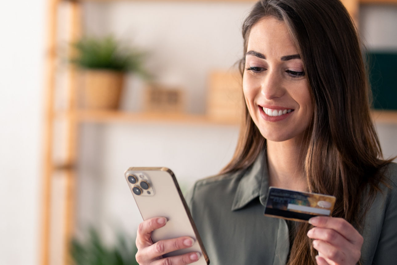 Junge Frau sitzt am Laptop und tippt auf der Tastatur