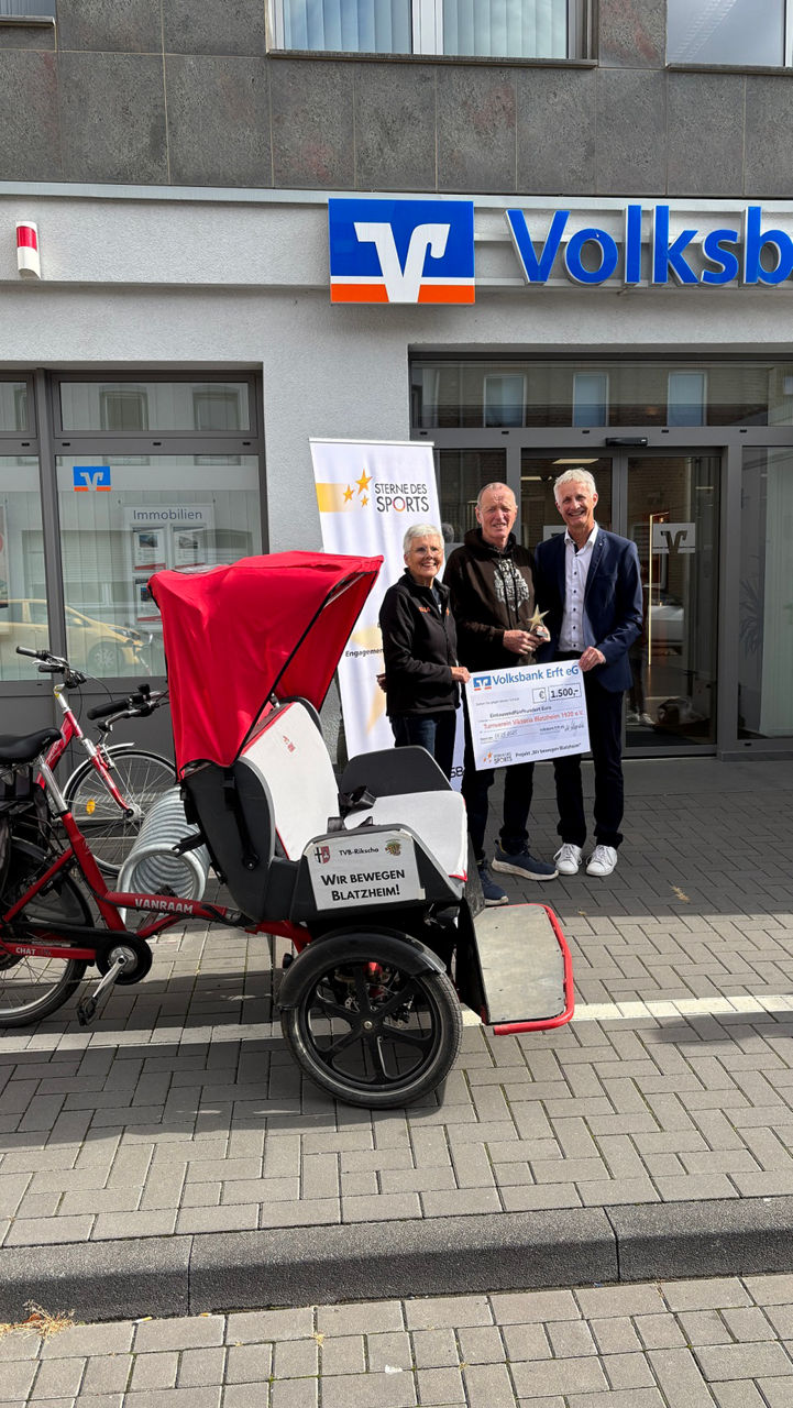 Zwei Vorstände übergeben einen Spendenscheck an zwei Vereinsmitglieder