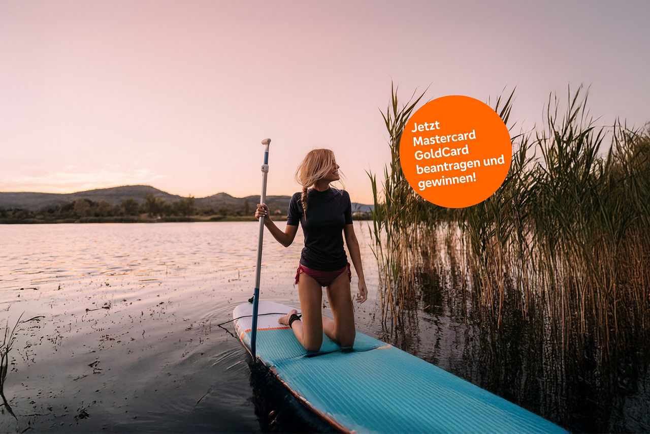 Eine Frau kniet auf einem Stand-Up-Paddle.