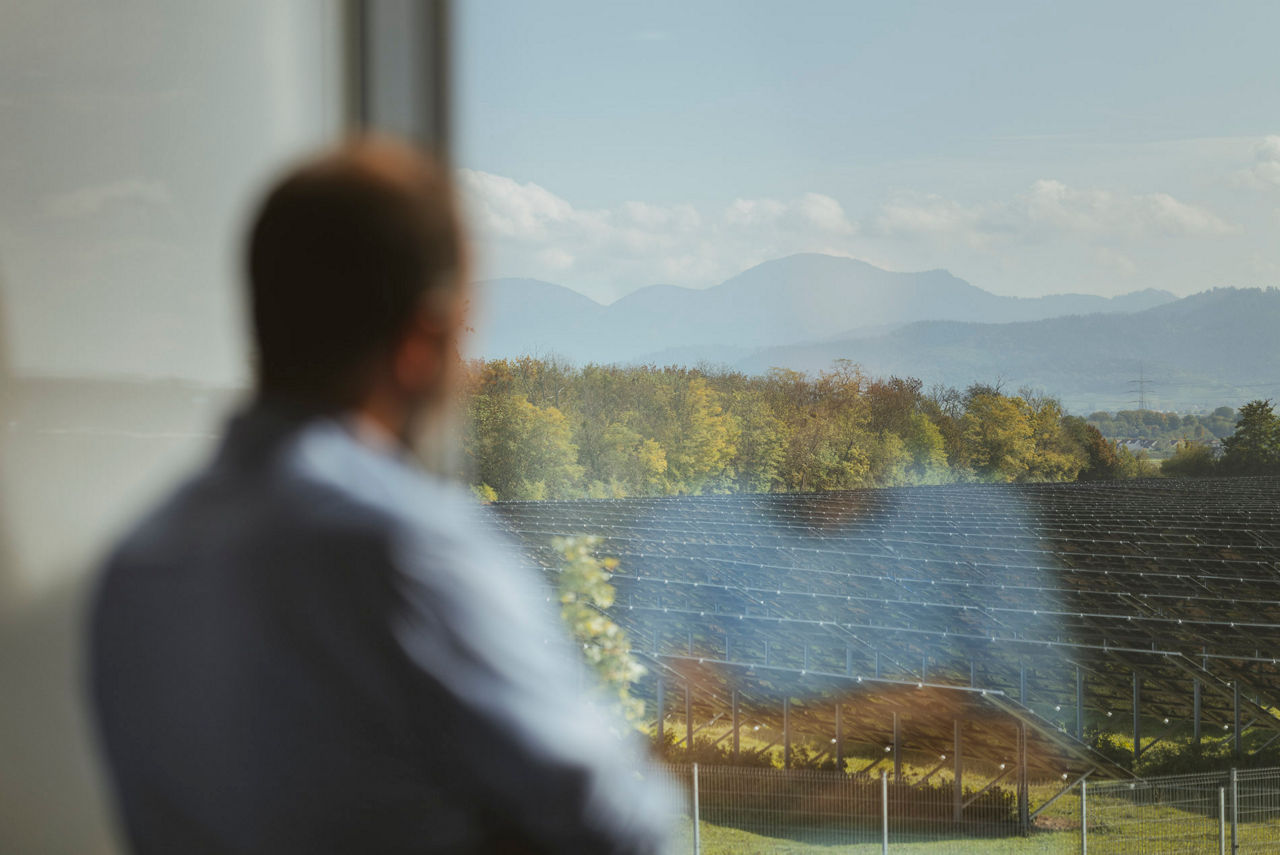 Ein Mann schaut aus dem Fenster auf den Schwarzwald