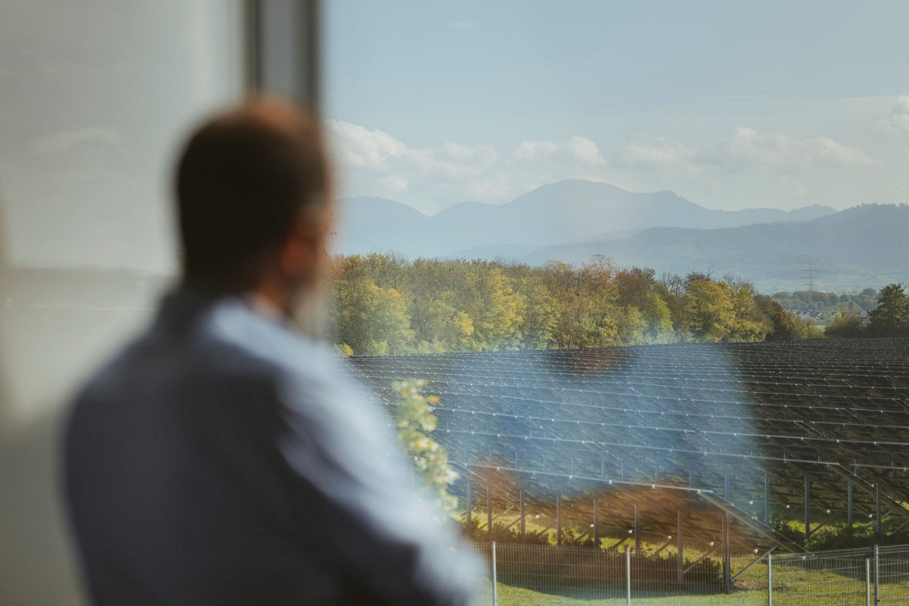 Ein Mann schaut aus dem Fenster auf den Schwarzwald
