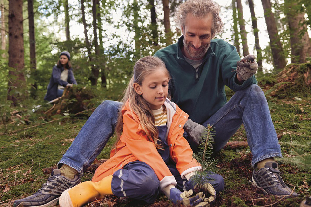 Ein Vater pflanzt mit der Tochter einen Baum 
