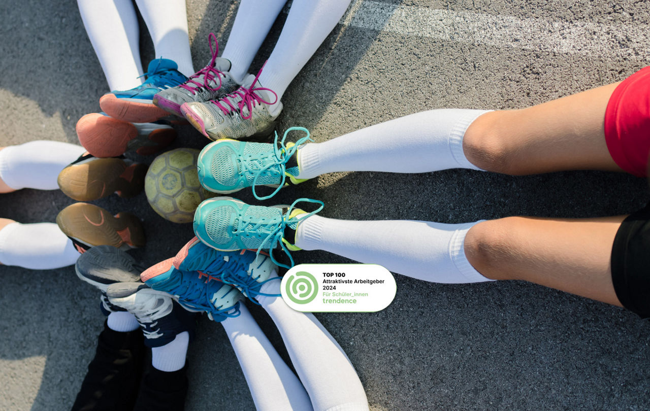 Veschiedene Turnschuhe eines Fußballteams rund um einen Fußball