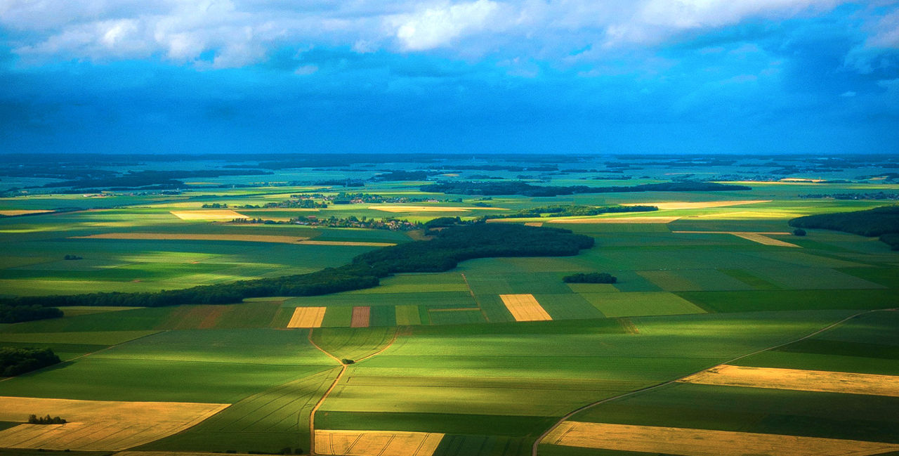 Luftbild einer Region mit Feldern, Wiesen und Wäldern