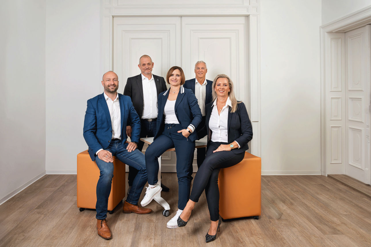 Abbildung der Tochterfirma Volksbank Mittweida Immobilien - 4 Herren, 2 Damen in Business-Outfits
