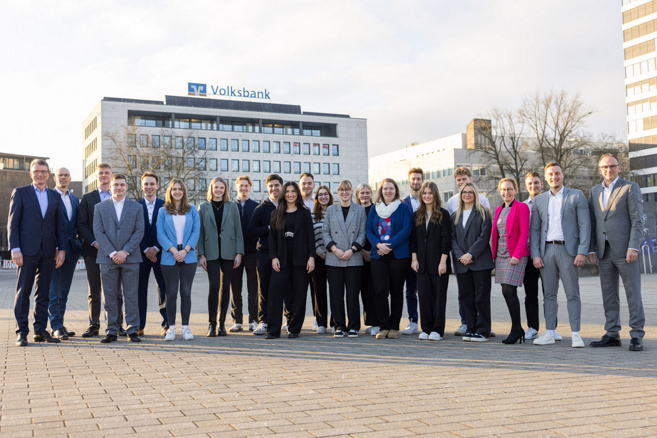 Gruppenbild vom erfolgreichen Volksbank-Nachwuchs mit Vorstand und Ausbildungsteam vor dem Regionalzentrum Bielefeld.