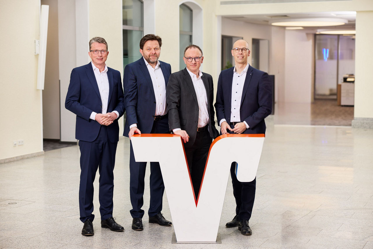 Die vier Vorstände der Volksbank in Ostwestfalen stehen hinter einem großen Volksbank "V".