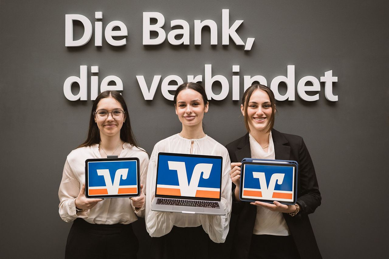 Drei Junge Menschen halten ein Tablett mit Volksbank Logo