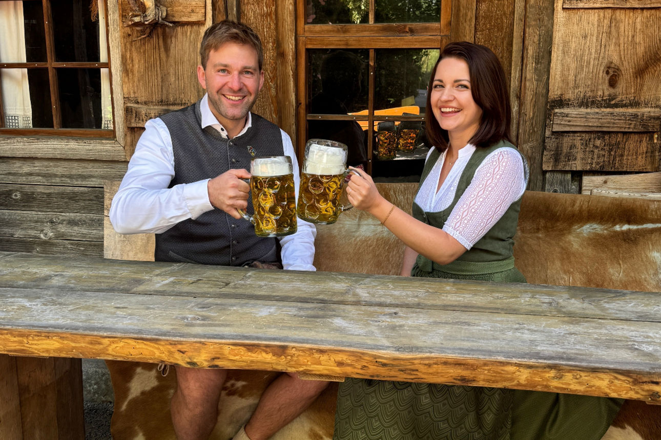 Marktbereichsleiter Sandro Knab und Privatkundenberaterin Svetlana Schacherbauer stoßen mit einer Maß Bier an