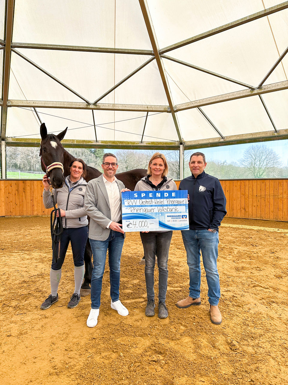 Mehrere Frauen sitzen an Tischen und hören zwei Frauen zu, von denen eine mit Mikrofon vor einem Bildschirm mit bunten Kreisen spricht                               
