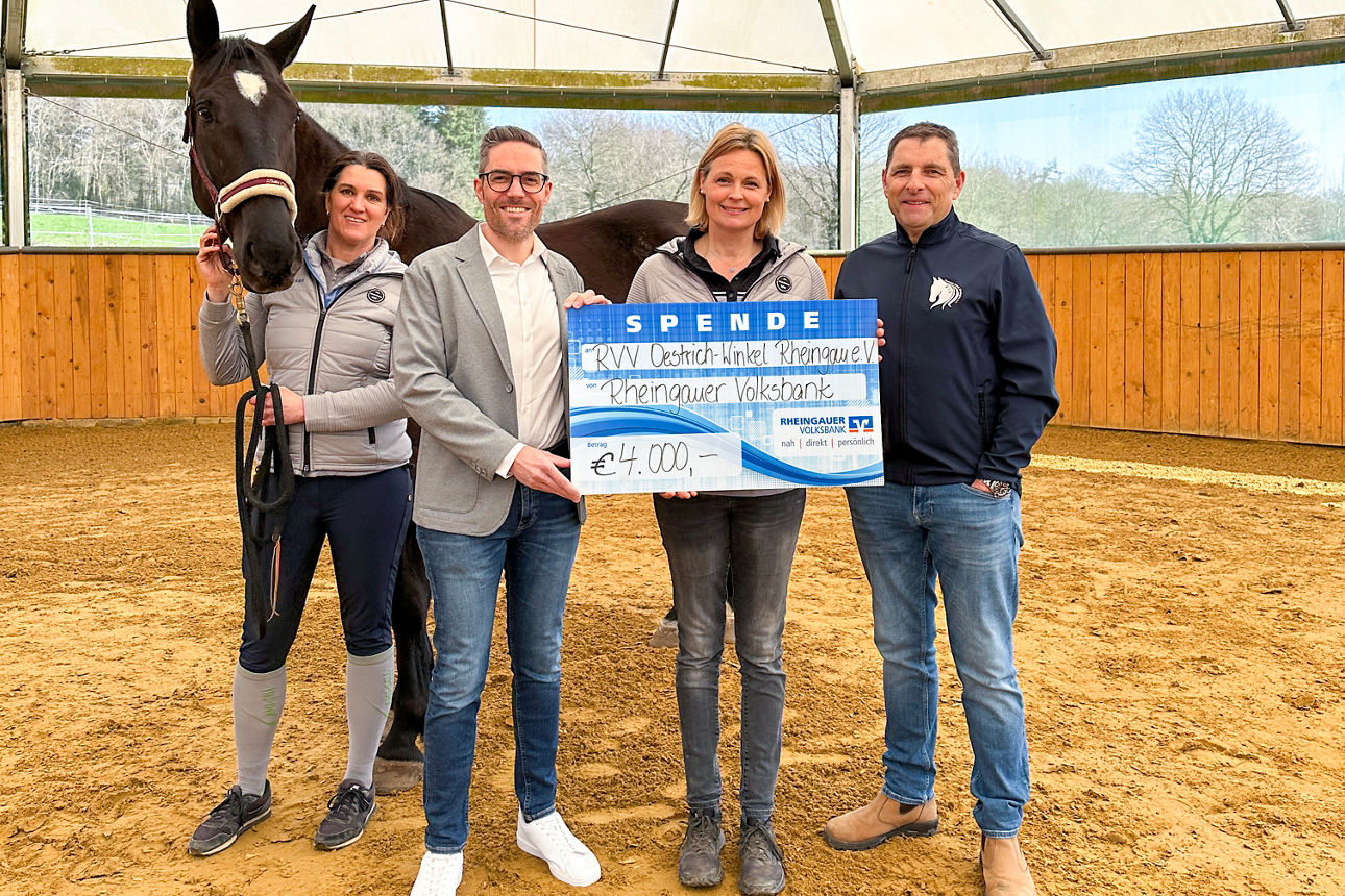 Vier Personen stehen nebeneinander und halten gemeinsam einen gerahmten Text mit Auszeichnung