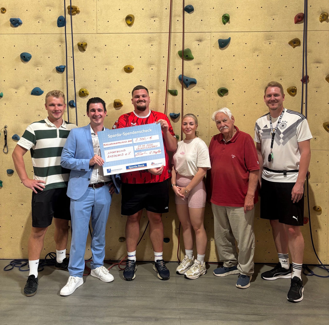 mehrere Menschen vor einer Kletterwand mit einer 2500 € Spende