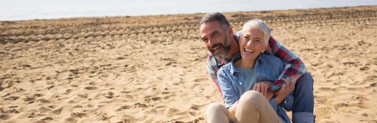 Ein Paar spaziert am Strand, Händchen haltend, mit den Wellen des Meeres