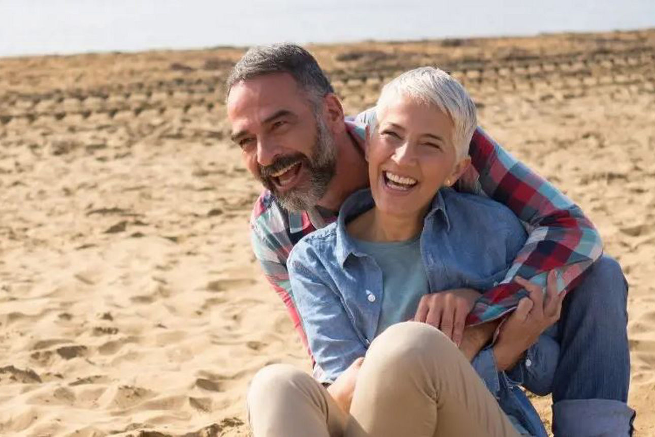 Ein Paar spaziert am Strand, Händchen haltend, mit den Wellen des Meeres