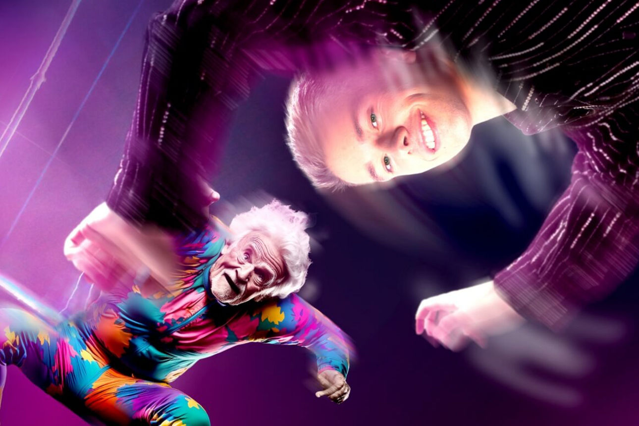 Artist schwebt und reicht springendem Senior die Hände zum Absichern