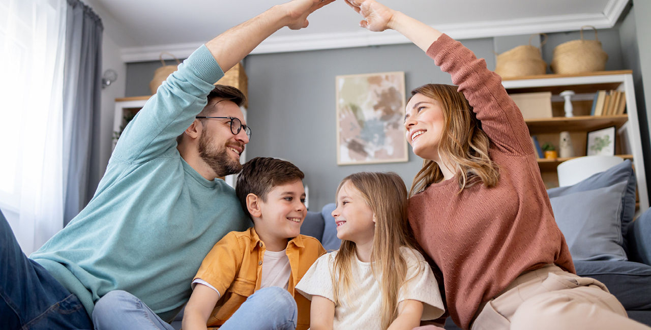 Junge Familie sitzt entspannt zu Hause auf dem Sofa