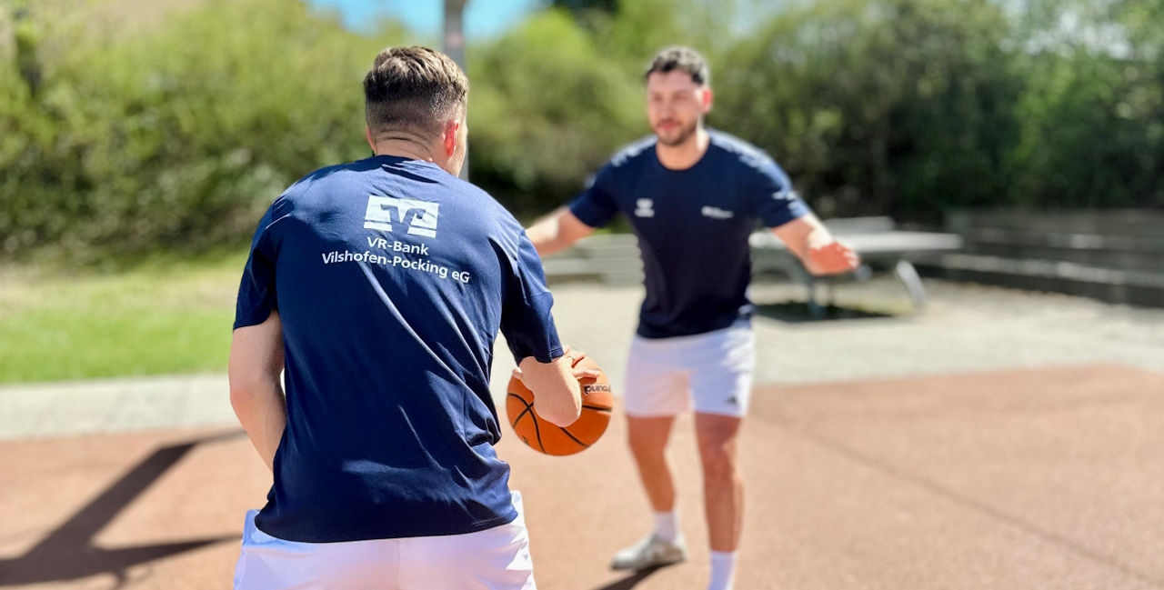 Zwei junge Männer spielen Basketball
