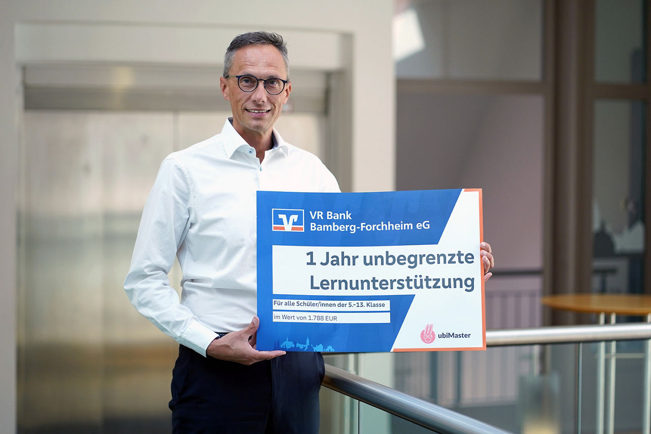 Vorstand Joachim Hausner präsentiert symbolischen Scheck für 1 Jahr unbegrenzte Lernunterstützung