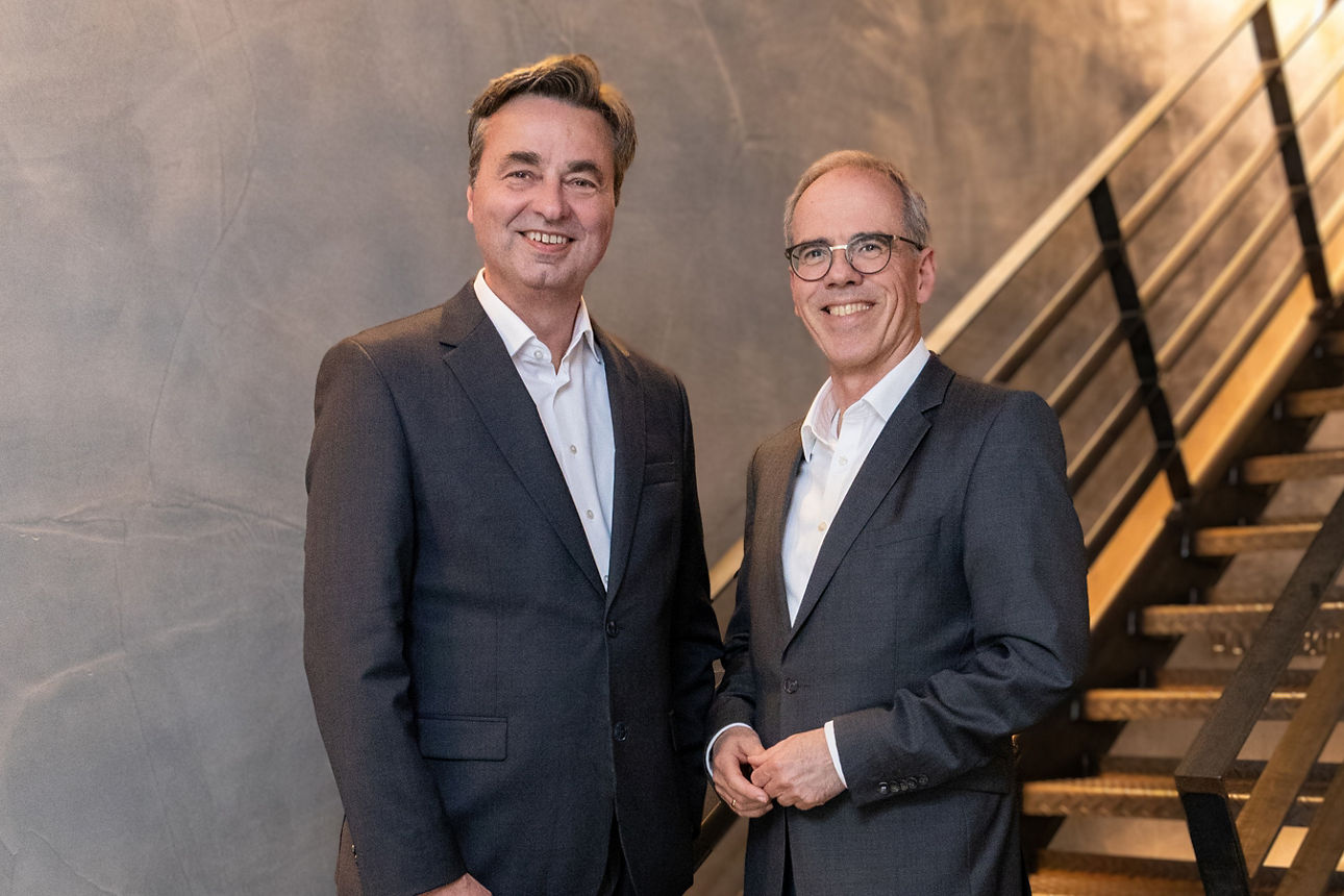 Vorstände Jörg Lott und Ingo Abrahams stehen vor einer Treppe