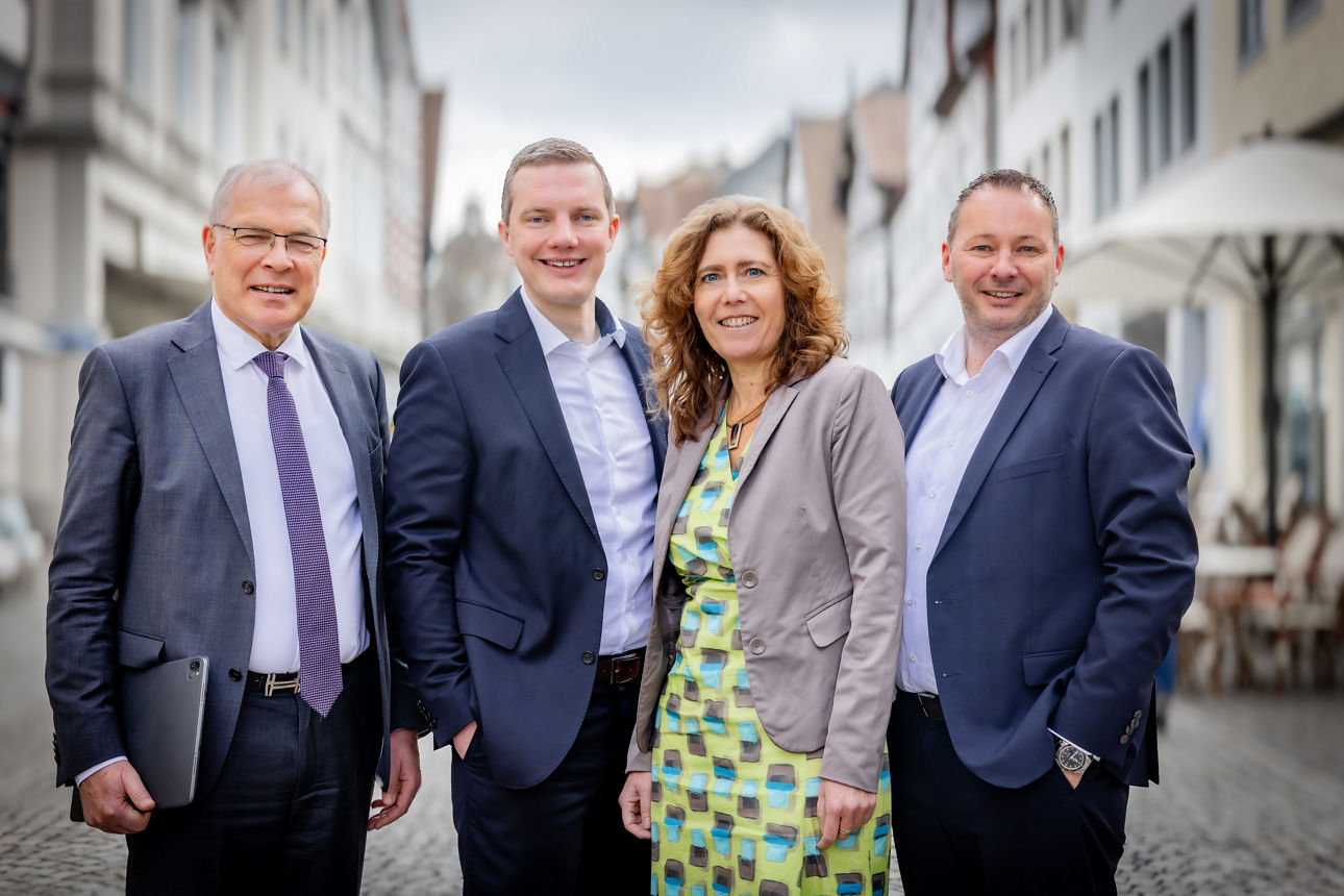 Drei Männer und ein Frau stehen auf der Strasse