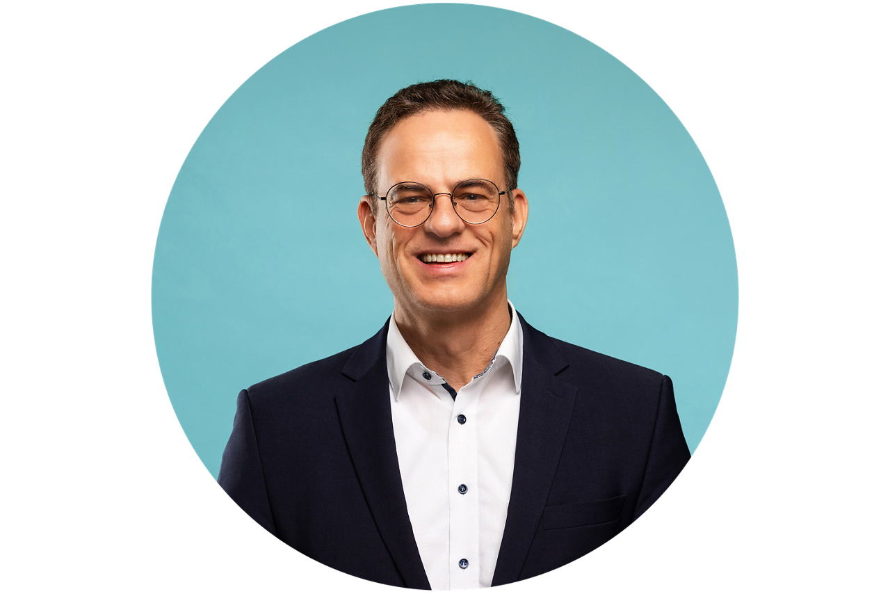 Porträt von Torsten Hopf, Vorstand der VRRegionalBank, vor hellblauem Hintergrund in dunklem Anzug und weißem Hemd.