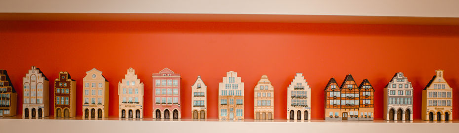 Die Häuser sind in einem alten Baustil dargestellt, angelehnt an den Baustil der Altstadt in Münster