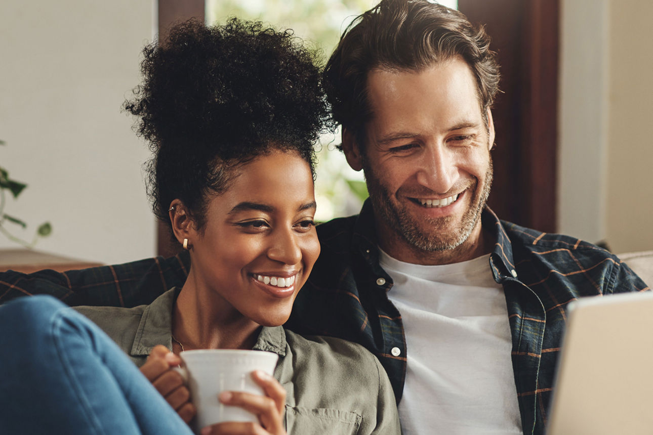 Mann mit Tablet und Frau mit Kaffee auf dem Sofa