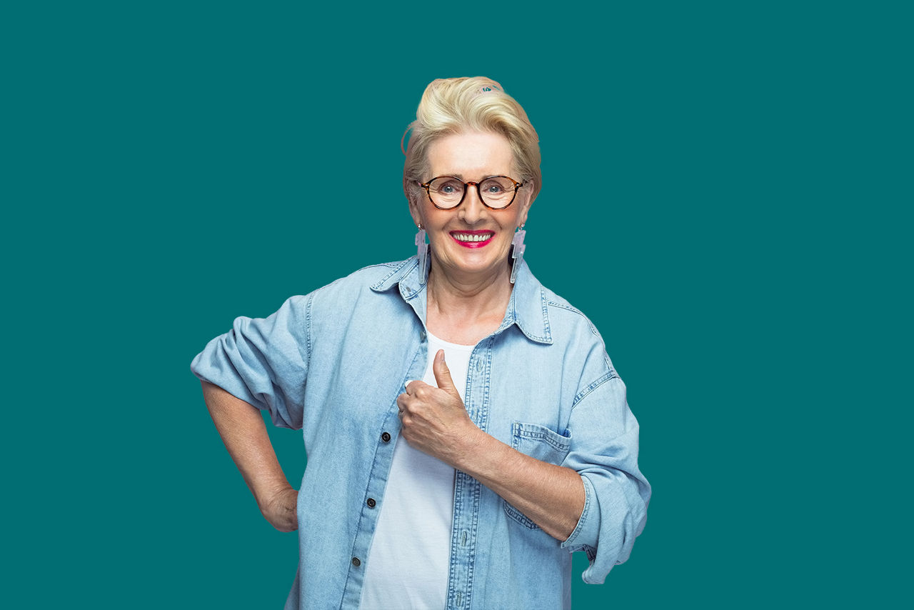 Frau steht lächelnd vor einer grünen Wand
