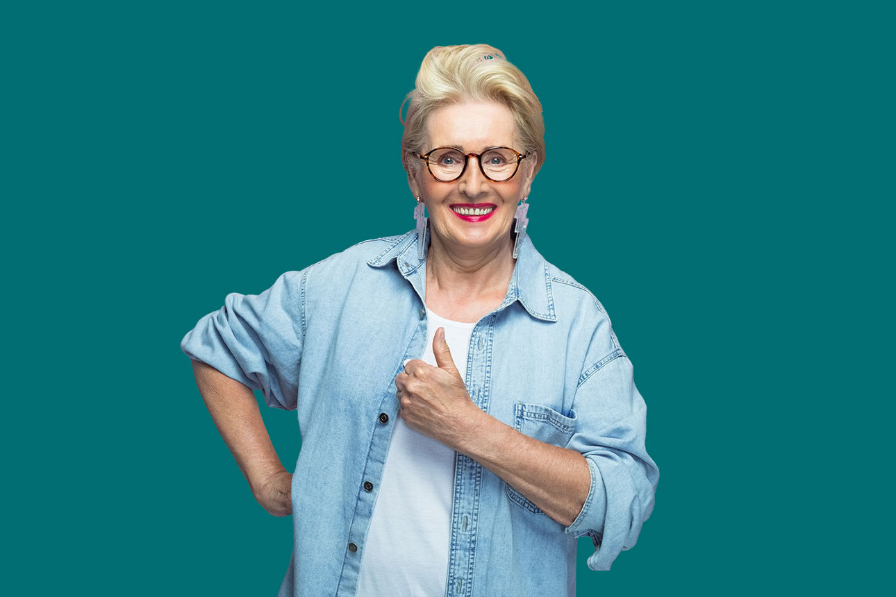 Frau steht lächelnd vor einer grünen Wand