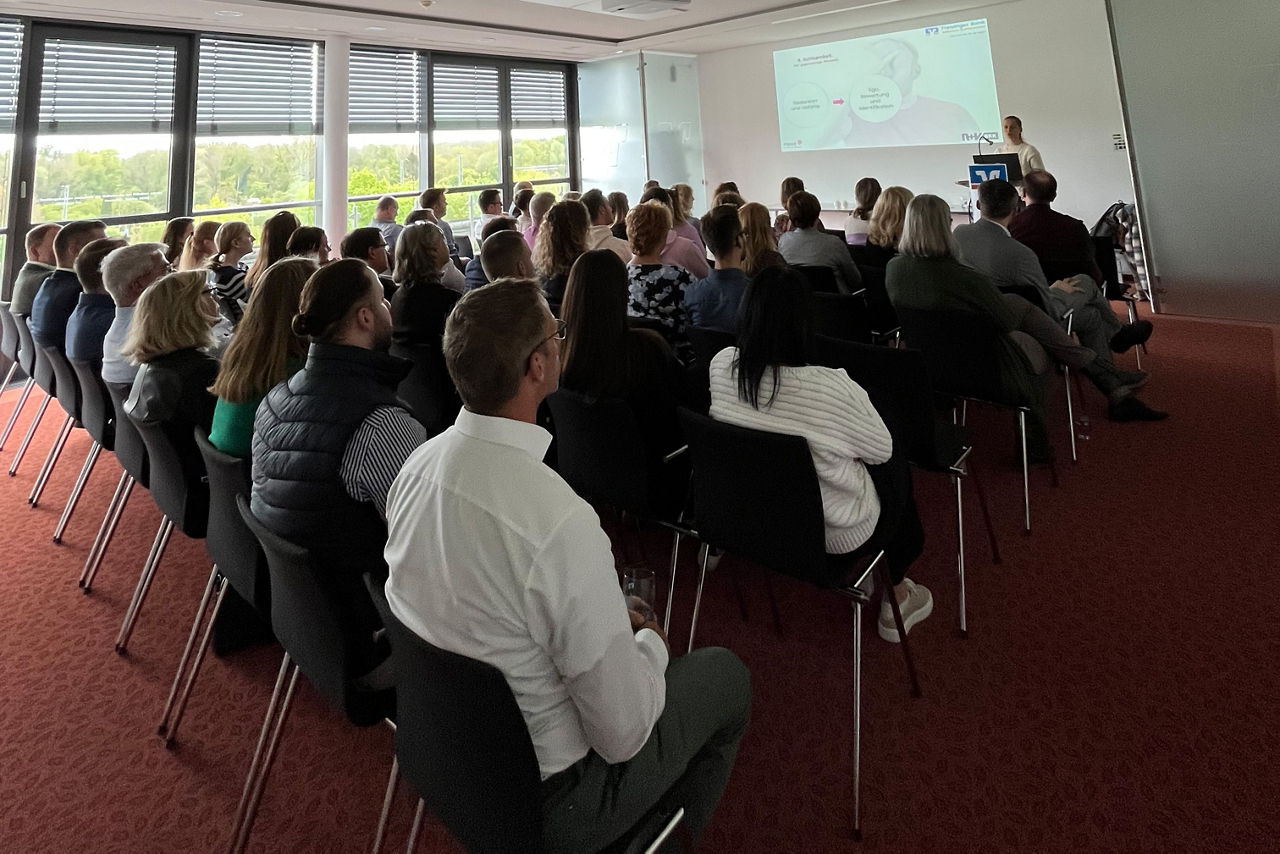 Zwei Herren posieren mit einer Urkunde für die bestandene Weiterbildung