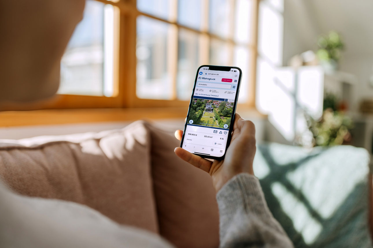 Mann in einer U-Bahn-Station, der auf sein Smartphone schaut